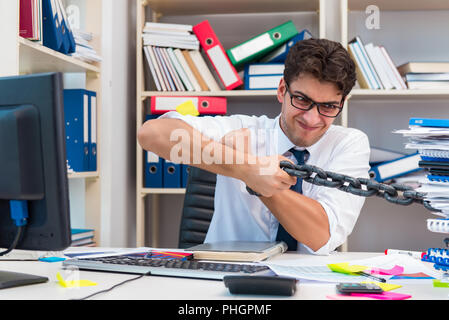 Employé attaché et enchaîné à son bureau avec chaîne Banque D'Images