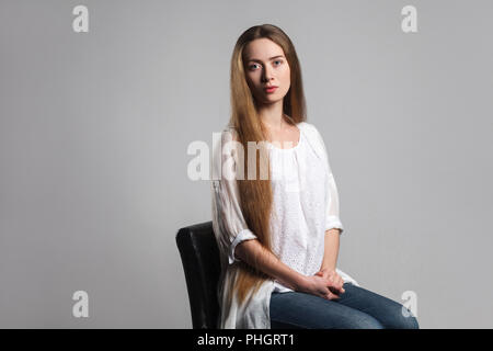 Portrait du jeune acteur modèle émotionnel belle avec de longs cheveux bruns en t-shirt blanc sur noir et président de séance à huis clos au regard profond avec. Je Banque D'Images