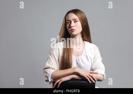 Portrait du jeune acteur modèle émotionnel belle avec de longs cheveux bruns en t-shirt blanc sur noir et président de séance à huis clos à la triste avec des gaz Banque D'Images