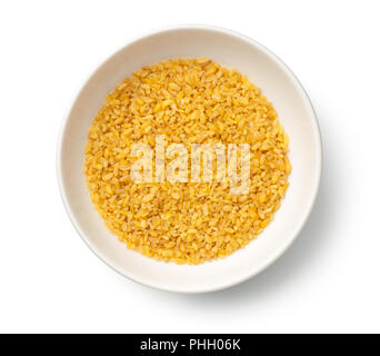 Les grains de blé bulgur et sec dans un bol isolé sur fond blanc Banque D'Images
