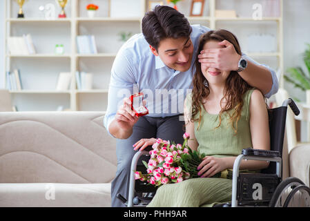 Man making proposition de mariage pour femme handicapée sur fauteuil roulant Banque D'Images
