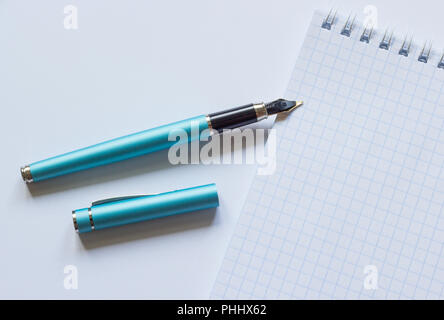 Bloc-notes et stylo sur un fond blanc Banque D'Images