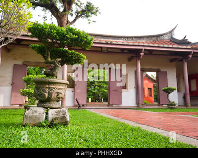 La porte de couleur rouge de style chinois et porte de temple à l'architecture traditionnelle chinoise style avec bonsaï en pot style Dragon dans le parc, Confucius Banque D'Images