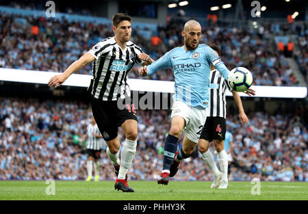 Le Newcastle United Federico Fernandez (à gauche) et Manchester City's David Silva (à droite) bataille pour la balle durant le premier match de championnat à l'Etihad Stadium, Manchester. Banque D'Images