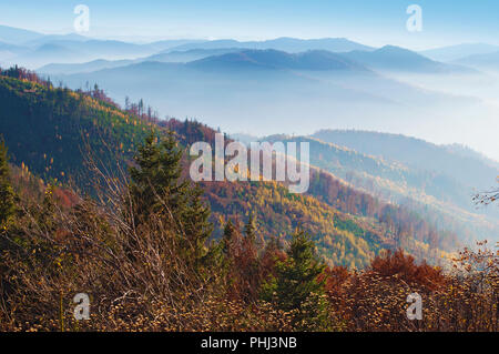 Vue sur les collines d'un smoky mountain range couverts en rouge, orange et jaune forêt de feuillus et pins verts sous un ciel sans nuage bleu sur fal chaud Banque D'Images