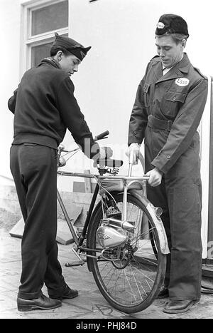 1950 Location en sus. Le fabricant allemand de cyclomoteurs et moteur fournit cette aide Victoria location moteur appelé Vicky. Il peut être monté sur tout les vélos de la roue comme un équipement supplémentaire. Il dispose de 2 ch et deux pignons. Lorsqu'il est utilisé il n'y a pas de taxe ou de permis de conducteurs neccesary. Lors de l'achat de location et le moteur en même temps, le prix est de 690 sek. Ici le jeune adolescent qui obtient le réservoir d'essence rempli à une station d'essence Esso. La Suède 1950 Photo Kristoffersson 1-1 Banque D'Images