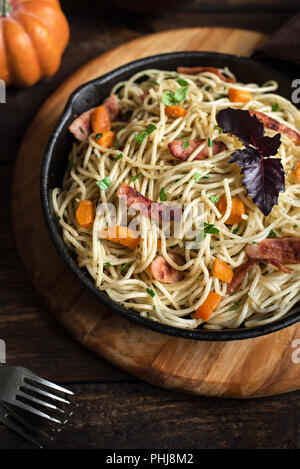 L'automne des pâtes avec du bacon et de citrouille dans poêle en fonte. Spaghetti maison des pâtes au potiron, en l'espace de copie. L'alimentation de l'automne. Banque D'Images