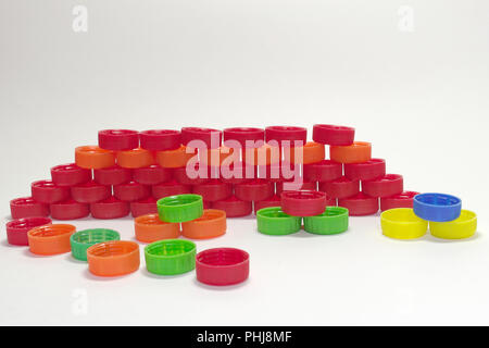 Mur de bouchons en plastique coloré pour les bouteilles de boissons. dispersés caps, empilés dans les petites pyramides Banque D'Images