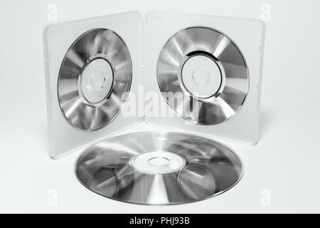 Cas pour mini CD. Plateaux intérieur de la boîte en plastique double face avec disques irisés sur les clips et pile de disques de tailles différentes en noir et blanc. Banque D'Images