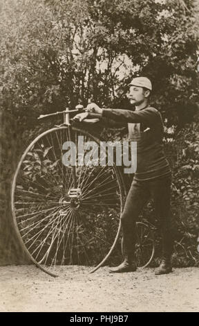 Penny Farthing location. Un homme est debout à côté d'un penny farthing-vélo. Un bicycycle modèle avec une grande roue avant et une petite roue arrière. Suède 1880 Banque D'Images