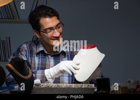 Bijoutier de jeunes hommes travaillant de nuit dans son atelier Banque D'Images