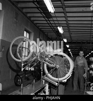 Location factory dans les années 1950. Un travailleur sur le fabriquant de vélos de Nymans à Uppsala travaille sur la ligne de production avec des vélos pour femmes. La Suède 1956 ref CV15-9 Banque D'Images