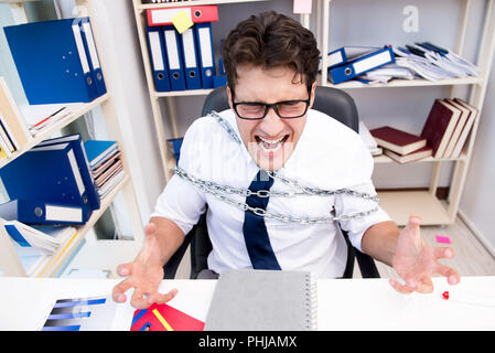 Employé attaché et enchaîné à son bureau avec chaîne Banque D'Images