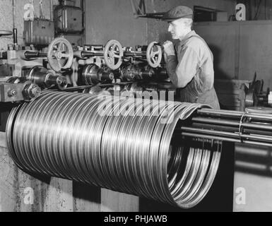 Factory dans les années 1950. Un travailleur de la société moto et vélo Monark en Suède. La machine produit des jantes en acier pour être utilisés dans la production de bicyclettes . Suède 1958 Banque D'Images