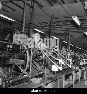 Location factory dans les années 1950. Un travailleur sur le fabriquant de vélos 1953 à Varberg. Sur la ligne de production sont womens modèles de bicyclettes en cours d'assemblage. Suède 1956 Banque D'Images