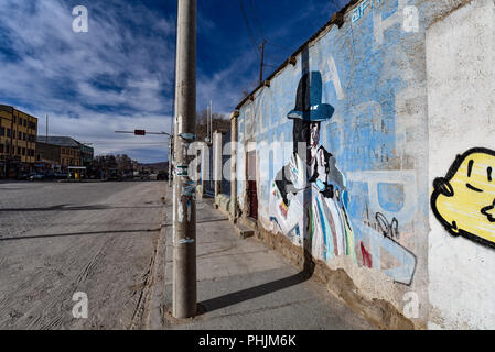 Art urbain coloré représentant une dame en robe traditionnelle andine sur un mur à Uyuni, Bolivie Banque D'Images