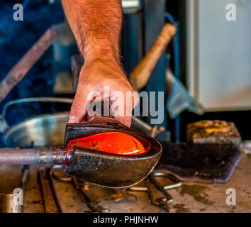 Un souffleur de verre en verre fondu chaud tournant Banque D'Images