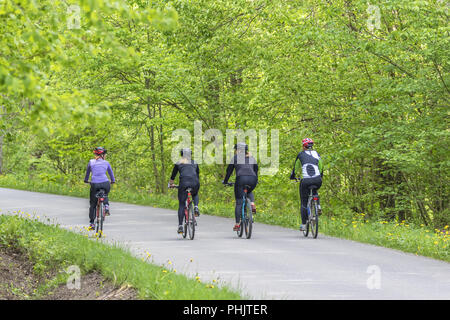 Les jeunes femmes qui exercent sur les bicyclettes dans la campagne Banque D'Images