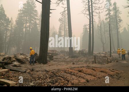 Fireman fouillent dans les vestiges d'une maison transformée en cendres de Taylor Creek Klondike et la gravure dans la Forêt Nationale Siskiyou Rogue River 11 août 2018 près de Grants Pass, Oregon. Banque D'Images