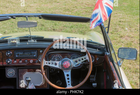 Une voiture de sport britannique mg battant drapeau Union Jack ou du pare-brise. Vintage MG Midget ot MGB GT sports car la planche de bord fait en noyer. Banque D'Images