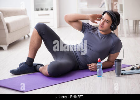 Faire du sport l'homme à la maison et à l'écoute de musique Banque D'Images
