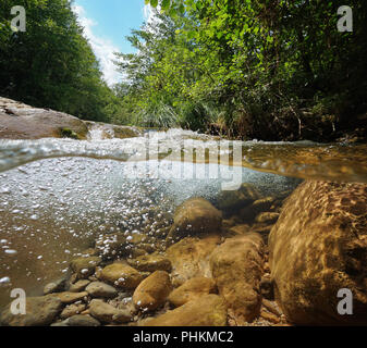 Flux avec la végétation et les roches avec des bulles d'air sous l'eau, vue fractionnée au-dessus et au-dessous de la surface de l'eau, la Muga, Girona, Alt Emporda, Catalogne, Espagne Banque D'Images