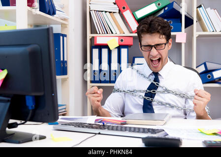 Employé attaché et enchaîné à son bureau avec chaîne Banque D'Images