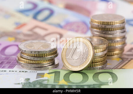 Beaucoup de billets de monnaie européenne fixant sous pièces empilées Banque D'Images