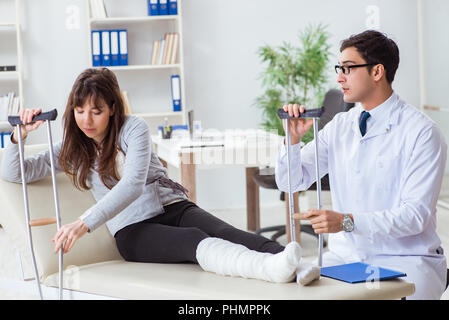 Doctor examining patient avec jambe cassée Banque D'Images