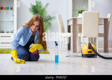 Jeune femme à la maison de plancher nettoyage petits travaux Banque D'Images