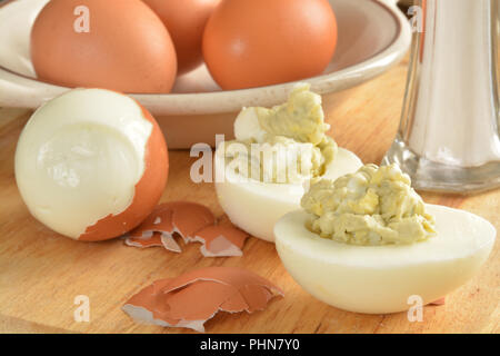 Oeufs durs et salade d'œufs sur une planche à découper avec du sel Banque D'Images