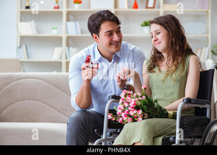 Man making proposition de mariage pour femme handicapée sur fauteuil roulant Banque D'Images