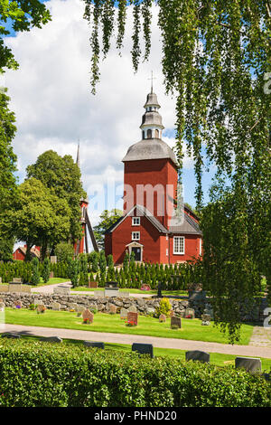 Cimetière avec une église en bois rouge Banque D'Images