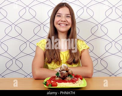 Happy girl avec des spaghetti et boulettes de viande pour le déjeuner Banque D'Images