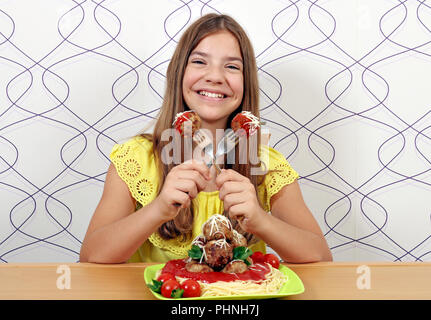 Happy smiling girl avec des spaghetti et boulettes de viande pour le déjeuner Banque D'Images