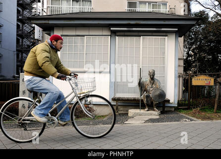 Un homme d'un passé cycles memorial statue de bronze du 17e siècle célèbre poète japonais Basho Matsuo près d'un parc commémoratif à Tokyo, Japon. Basho est meilleur kno Banque D'Images