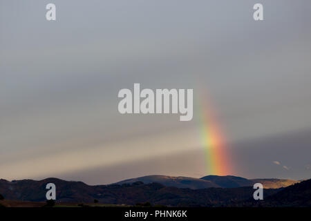 Belle et surréaliste vue d'une partie d'un arc-en-ciel sur certaines collines Banque D'Images