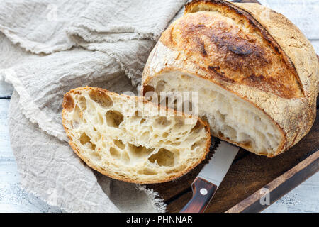 Couper une miche de pain au levain artisanal sur. Banque D'Images