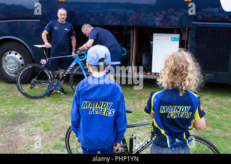 Pembrey Country Park, Pembrey, Pays de Galles, Royaume-Uni. Dimanche 2 septembre 2018. Deux jeunes cyclistes de Maindy Flyers regarder comme des vélos de course de l'équipe Movistar sont déchargés de l'avant de l'étape 1 du Tour de Bretagne cycliste à partir de Pembrey Country Park. Banque D'Images