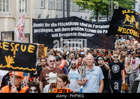 Hambourg, Allemagne. 09Th Nov, 2018. 02.09.2018, Hambourg : les participants de la manifestation quai portent une bannière avec l'inscription "pensez-vous que les réfugiés s'est parti sur les bateaux, avec le grand rêve de s'occuper des drogues dans le parc ? Photo : Markus Scholz/dpa/Alamy Live News Banque D'Images