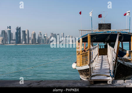 DOHA, QATAR - Dec 2018 : Échelle de Corniche sur Broadway bateau traditionnel en bois du golfe d'inviter à tour touristique de la ville. Belle vue sur la ville de Doha avec Qatar flottante avec des drapeaux. Le Qatar, au Moyen-Orient Banque D'Images