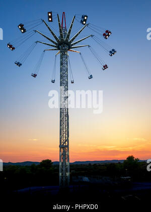 Swing ride. Star Flyer. Manège dans le coucher du soleil. Banque D'Images