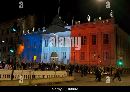 Copenhague, Danemark, 15 novembre, 2015. Des milliers de personnes à Copenhague montrent leur solidarité et sympathie avec le peuple français à l'extérieur de l'Ambassade de France à Copenhague après les attentats terroristes de vendredi dernier à Paris. L'énorme quantité de fleurs et messages pousse encore ce dimanche soir. Kongens Nytorv à Copenhague est éclairé par les couleurs du Tricolore Français projetée sur le bâtiment de l'ambassade française bondé encore après une journée de manifestations officielles et des actions spontanées de sympathie et de solidarité. Banque D'Images