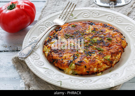 Rosti de pommes de terre suisse sur une plaque blanche. Banque D'Images