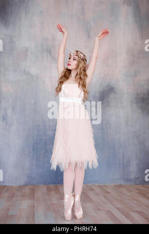 Belles jambes de jeune ballerine qui met sur les pointes à l'étage en bois blanc, arrière-plan, Vue de dessus du dessus avec copie espace. La pratique de ballet. Bea Banque D'Images