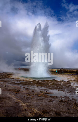 Le geyser Strokkur éclate en tant que touristes watch en Islande Banque D'Images