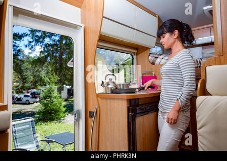 La cuisine femme dans le camping-car, Camping RV de l'intérieur. Vacances famille vacances, voyages voyage en camping-car, caravane location de vacances. Banque D'Images