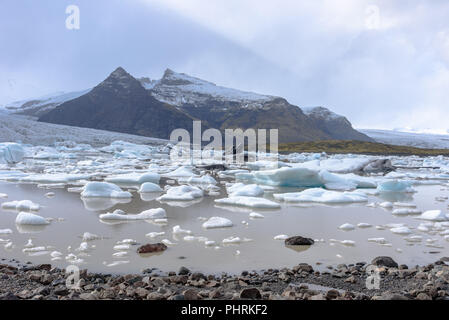 Les icebergs dans le Fjallsárlón lac glaciaire en Islande sur une journée avec des nuages Banque D'Images