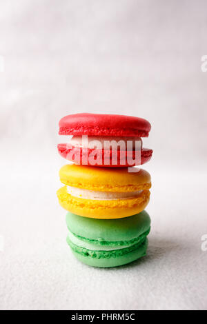 Différents types de macarons dans la pile sur fond blanc, feu doux, conceptuel copy space Banque D'Images