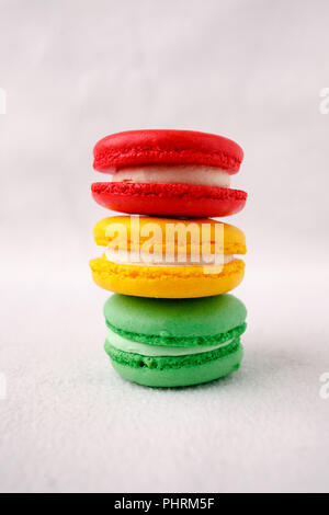 Différents types de macarons dans la pile sur fond blanc, feu doux, conceptuel copy space Banque D'Images